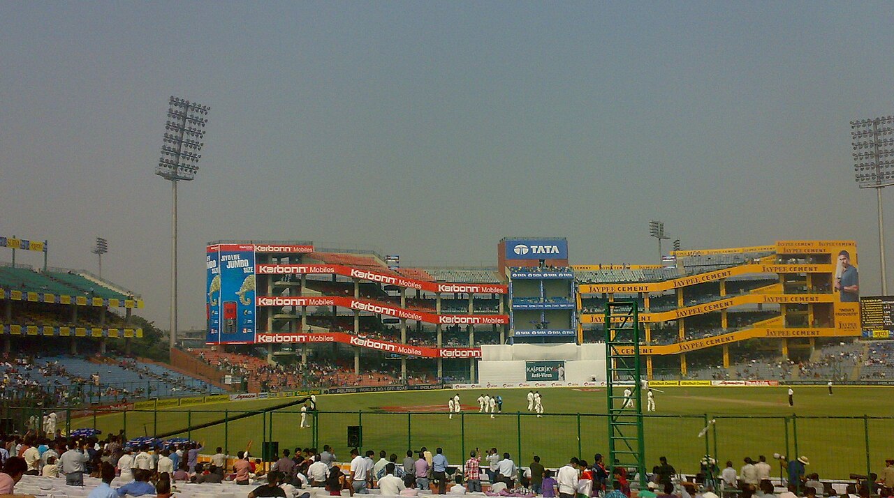 Cricket stadium in Delhi under lights on a winter evening
