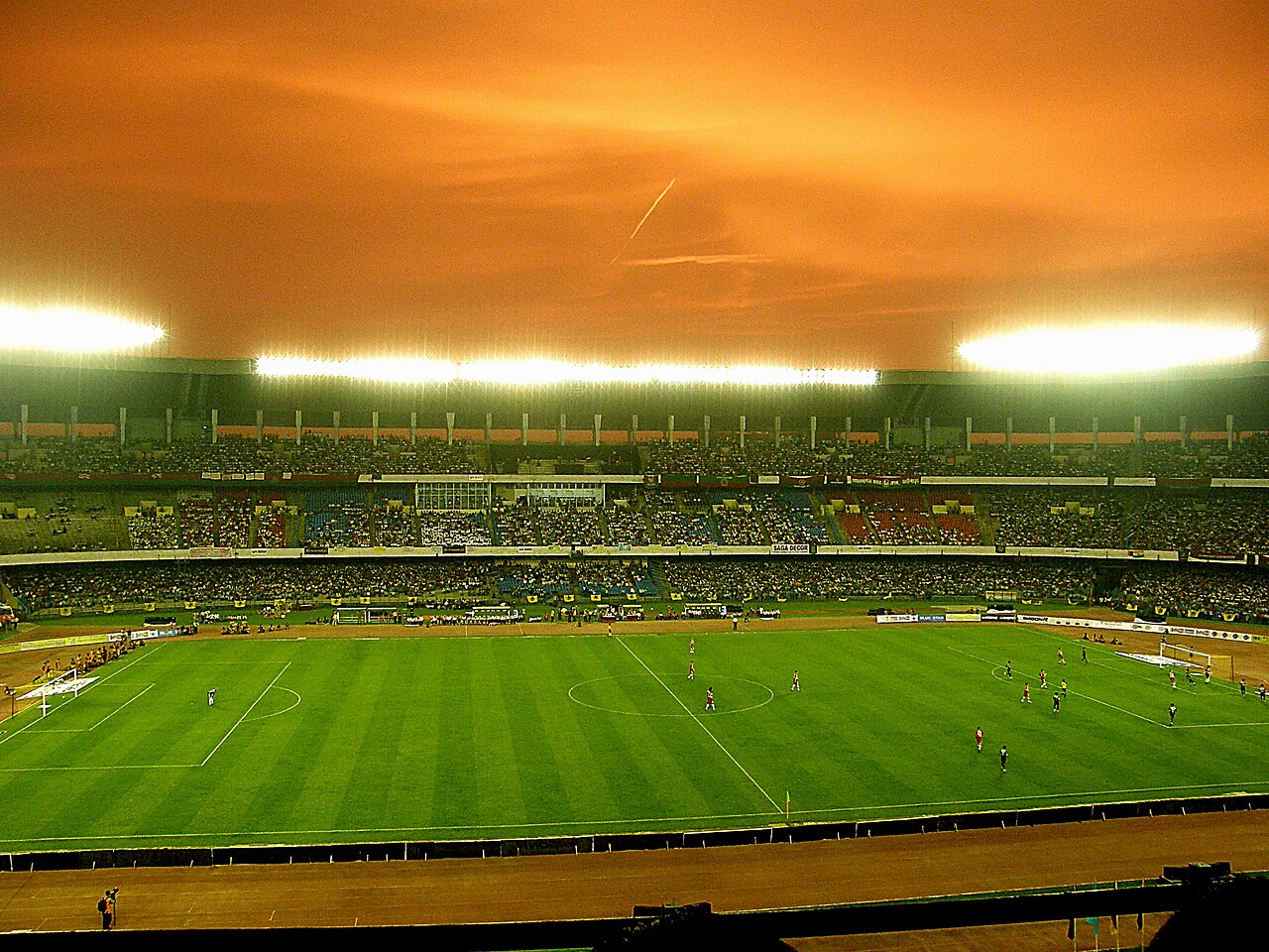 Packed tiered stands with club colours and banners before a Kolkata football derby